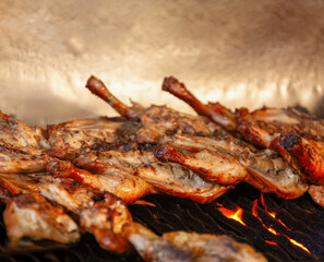 barbeque chicken legs on a grill cooking outdoors