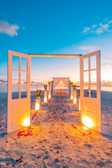 Romantic proposal sunset dinner. Candles white decoration pavilion, door close to sea sand beach. Love honeymoon anniversary dinner on tropical beach. Destination romance wedding, luxury couple travel