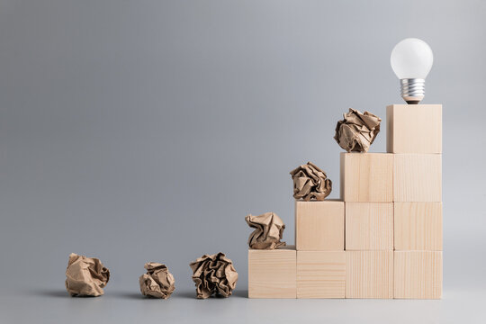 Crush paper balls and light bulb in concept of development and original idea, learn from mistakes, until success