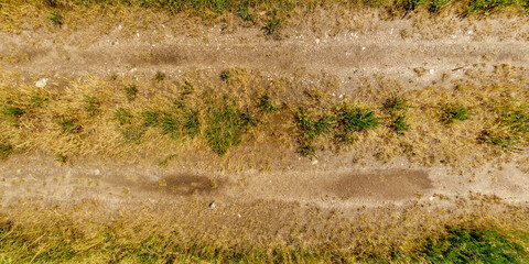 view from above on texture of wet gravel road with puddles after rain