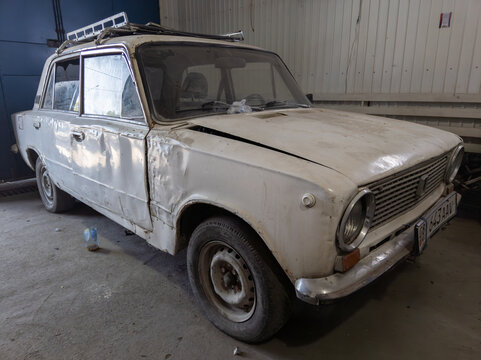 old beaten white soviet car in a car repair garage in Sokuluk, Kyrgyzstan - June 1, 2023
