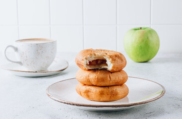 Cozy Morning: Aromatic Apple Fritters, Coffee with Milk, and a Green Apple on a Light Background. Selective focus