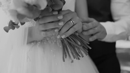 handsome groom businessman in a jacket touches his hands close-up to the bride in a white dress during a wedding walk, wedding day, details