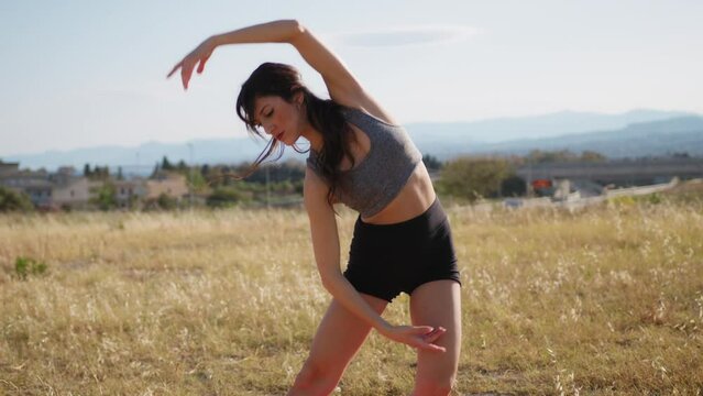 Young Woman Does Postural Stretching Relaxing Outside In Nature