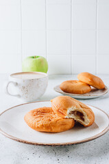 Cozy Morning: Aromatic Apple Fritters, Coffee with Milk, and a Green Apple on a Light Background. Selective focus