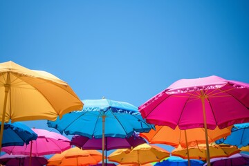 A close-up of vibrant beach umbrellas against a clear blue sky