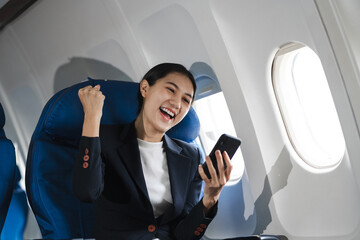 Waist up image of a fun business woman in an airline working on his computer while talking on a...