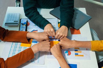 Close up view from top businesspeople putting hands together above the table express unity and support. Symbol gesture of friendship togetherness and like-minded people concept.