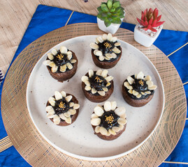 freshly Baked chocolate cupcakes with fudge icing and almond .