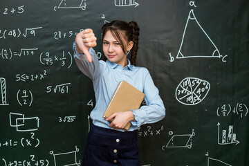 Schoolgirl girl shows her dissatisfaction with the school curriculum by putting her finger down.