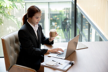 A beautiful young Asian businesswoman or female secretary working on her laptop computer in a office. businesspeople, technology