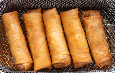 Fried spring roll in deep fryer basket. Chinese food