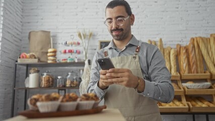 Young man taking photo with smartphone in bakery shop with various baked goods on display