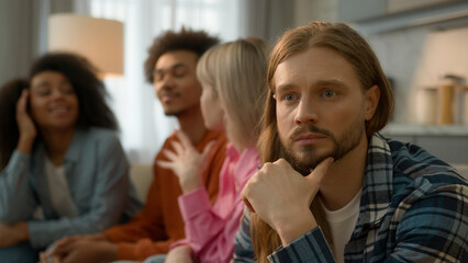 Obraz premium Caucasian sad pensive thinking troubled problem frustrated man guy introvert at home separated ignoring multiracial African multiethnic friends women men laughing talking antisocial outsider male