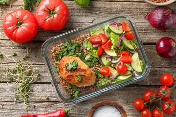 Healthy meal. Cutlet, buckwheat and salad in container near other products on wooden table, flat lay