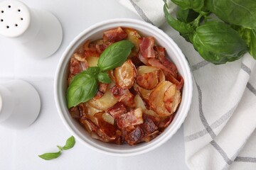 Delicious baked potatoes, bacon and basil on white table, top view