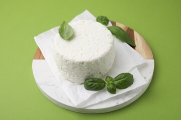 Fresh ricotta (cream cheese) and basil on green table