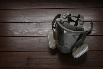 One respirator mask on wooden table, above view. Space for text