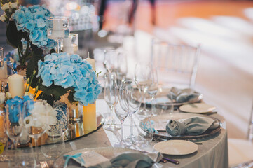 Wedding table settings. banquet table is decorated with plates, cutlery, glasses, candles and flower arrangements. 