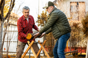 Two lumberjacks are setting up a piece of wood to be cut.