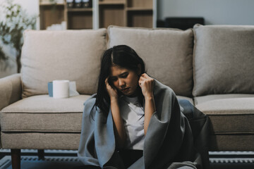 Cold medicine and sick woman drinking hot beverage to get well from flu, fever and virus. Dirty paper towels and tissues on table. Ill person wearing warm woolen stocking socks in winter.