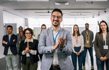 Obraz premium Portrait of man CEO standing in front of his multiracial colleagues and applauds.