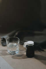 Cold medicine and sick woman drinking hot beverage to get well from flu, fever and virus. Dirty paper towels and tissues on table. Ill person wearing warm woolen stocking socks in winter.