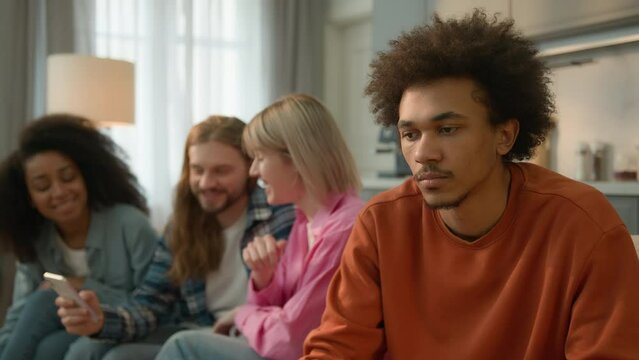 African American sad pensive thinking troubled problem frustrated man guy male at home separated ignore multiracial Caucasian multiethnic friends women men mobile phone using addicted laughing talking