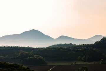 vista dettagliata di alcune alte colline in veneto, avvolte da della nebbia, di giorno, al tramonto