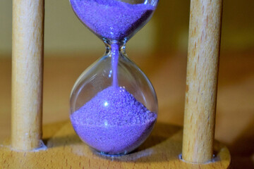 ancient wooden hourglass with sand of blue color