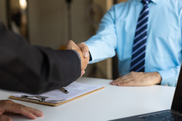 Employees shake hands after finishing a job interview.