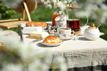 Beautiful table setting in spring garden on sunny day