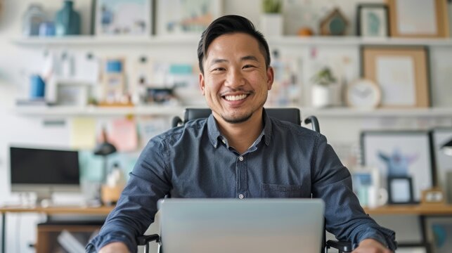 Happy Man in Wheelchair Working from Cozy Home Office with Personal Touches, Making Video Calls on Laptop - Front View