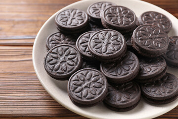 Many tasty sandwich cookies on wooden table