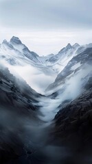 Misty mountain valley with snow-capped peaks
