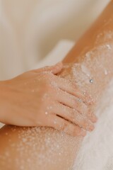 Fototapeta premium woman receiving a body treatment, with a professional applying an exfoliating scrub to her arm