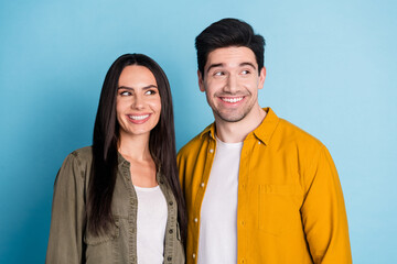 Portrait of two young people look empty space wear shirt isolated on blue color background
