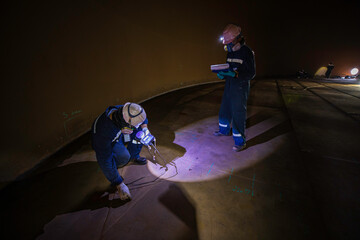 Male two worker inspection scan tank of rust thickness bottom plate area tank inside confined