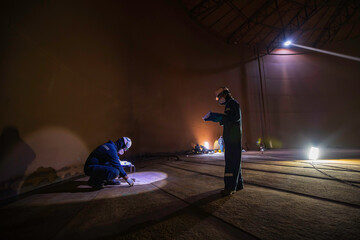 Male two worker inspection scan tank of rust thickness bottom plate area tank inside confined