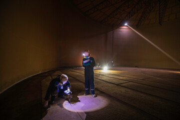 Male two worker inspection scan tank of rust thickness bottom plate area tank inside confined