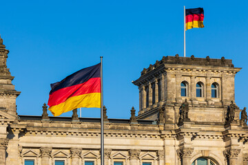 Symbolbild: Zwei Deutschlandflaggen auf und vor dem Reichstagsgebäude in Berlin wehen in...
