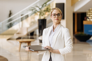 A modern blonde businesswoman arrives at a business hotel during a business trip. Business woman...