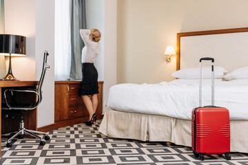 A business woman arrived at a modern hotel for a vacation or a business conference. A blonde businesswoman checks into her hotel room during her trip.