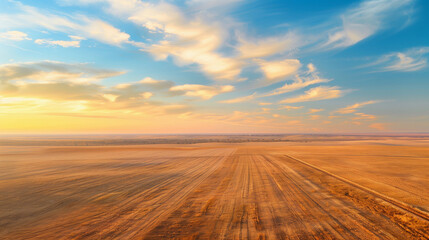 aerial view of expansive fields under colorful sky