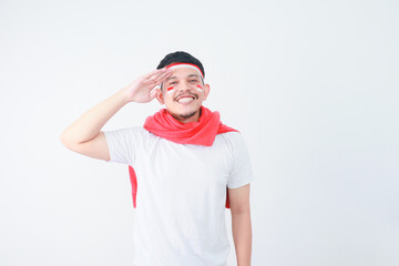 Naklejka premium Young Asian man standing confidently giving salute and respectful gestures isolated over white background. Celebrate Indonesia independence day on 17 August