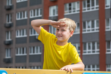 Portrait of a little boy wearing a yellow t-shirt