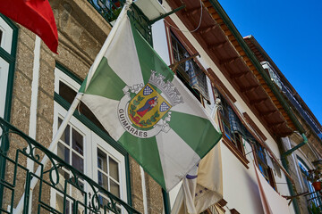 narrow streets in the city center of downtown Guimaraes with historical architecture in traditional portuguese style on a sunny day.