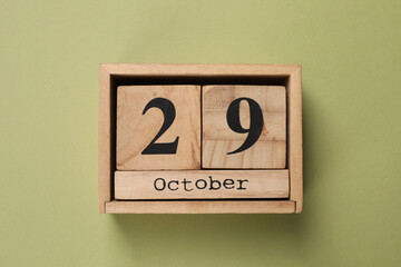 International Psoriasis Day - 29th of October. Block calendar on green background, top view