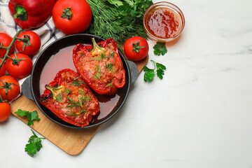 Tasty stuffed peppers in dish and ingredients on white table, flat lay. Space for text