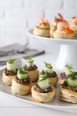 Delicious puff pastry with mushrooms, cucumber and dill on white wooden table